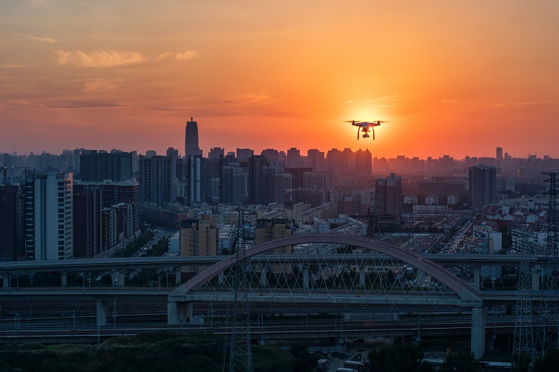 Drone flying over city at sunset
